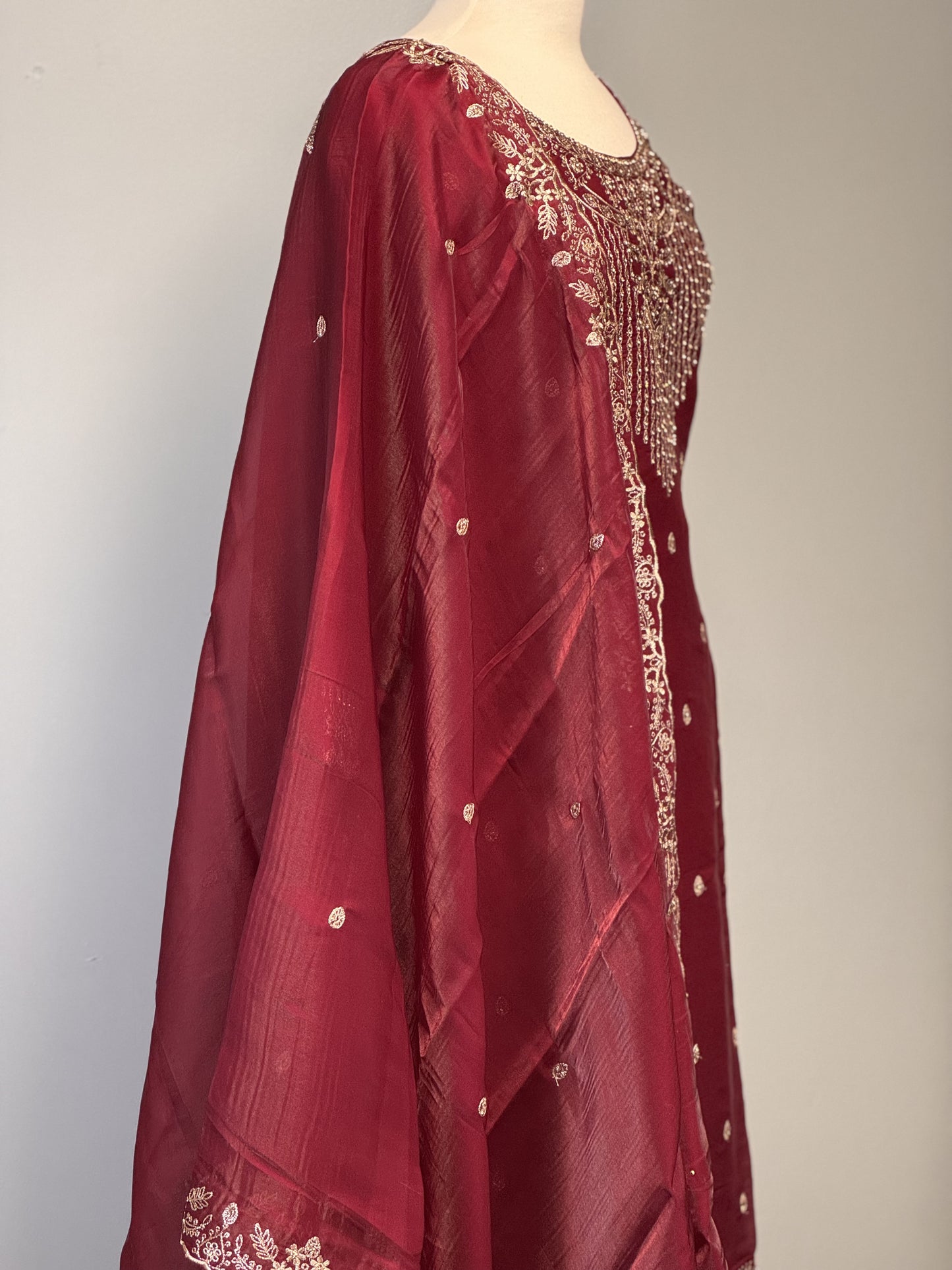 Adorned Maroon Salwar Suit with Golden Bead Accents.